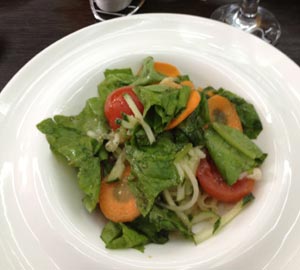 Листья зеленого салата со свежими овощами в ресторане Красные холмы